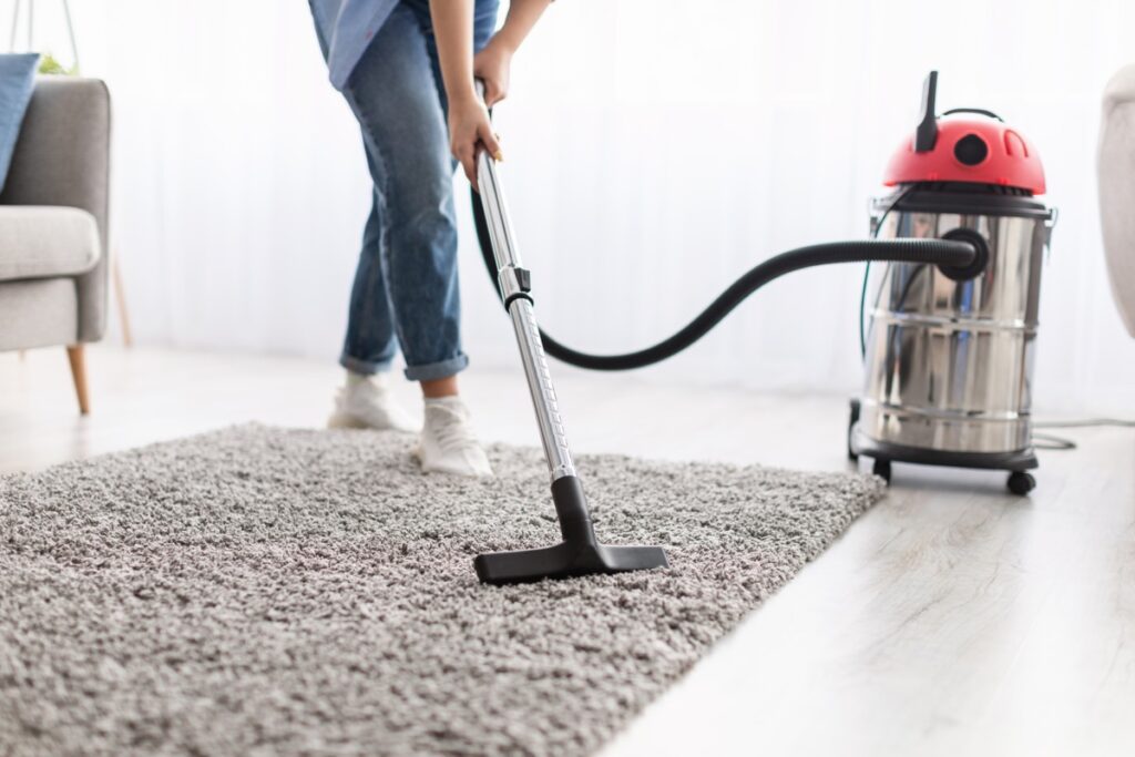 low section of woman cleaning carpet with vacuum c 2022 12 16 09 10 44 utc 1