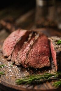 Juicy,Medium,Beef,Rib,Eye,Steak,Slices,On,Wooden,Board