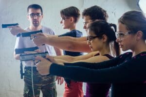 Large,Group,Of,Students,With,Two,Instructors,Practice,Gun,Shooting