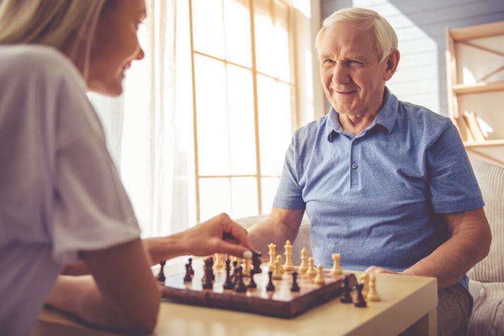 Beautiful,Young,Girl volunteer,And,Handsome,Old,Man,Are,Playing,Chess
