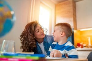 Kind,Mother,Helping,Her,Son,Doing,Homework,In,Kitchen.,Children's