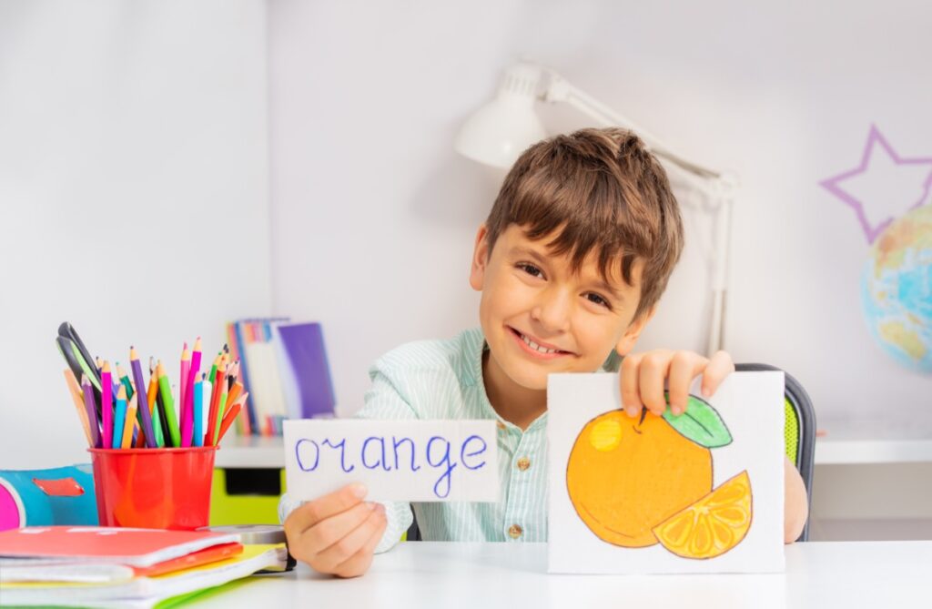 Smiling,Boy,In,Development,Class,With,Word,And,Object,Card