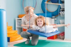 Happy,Boy,Lying,On,Swing,For,Vestibular,Therapy