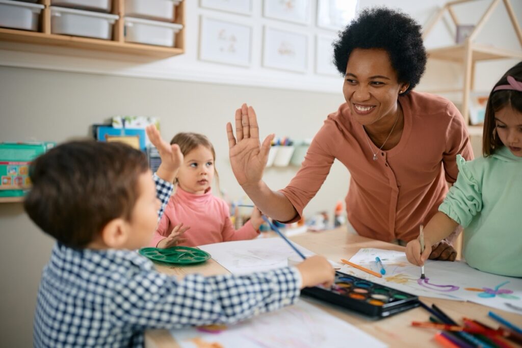 Happy,African,American,Teacher,And,Small,Boy,Giving,High five,During
