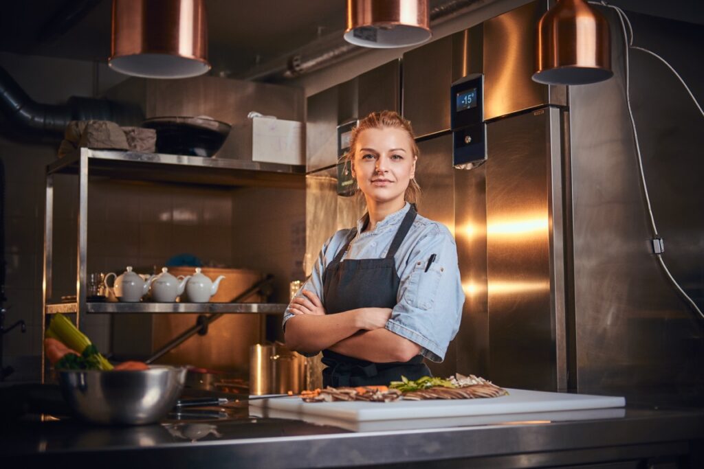 Confident,And,Serious,Female,Chef,Standing,With,Hands,Crossed,In