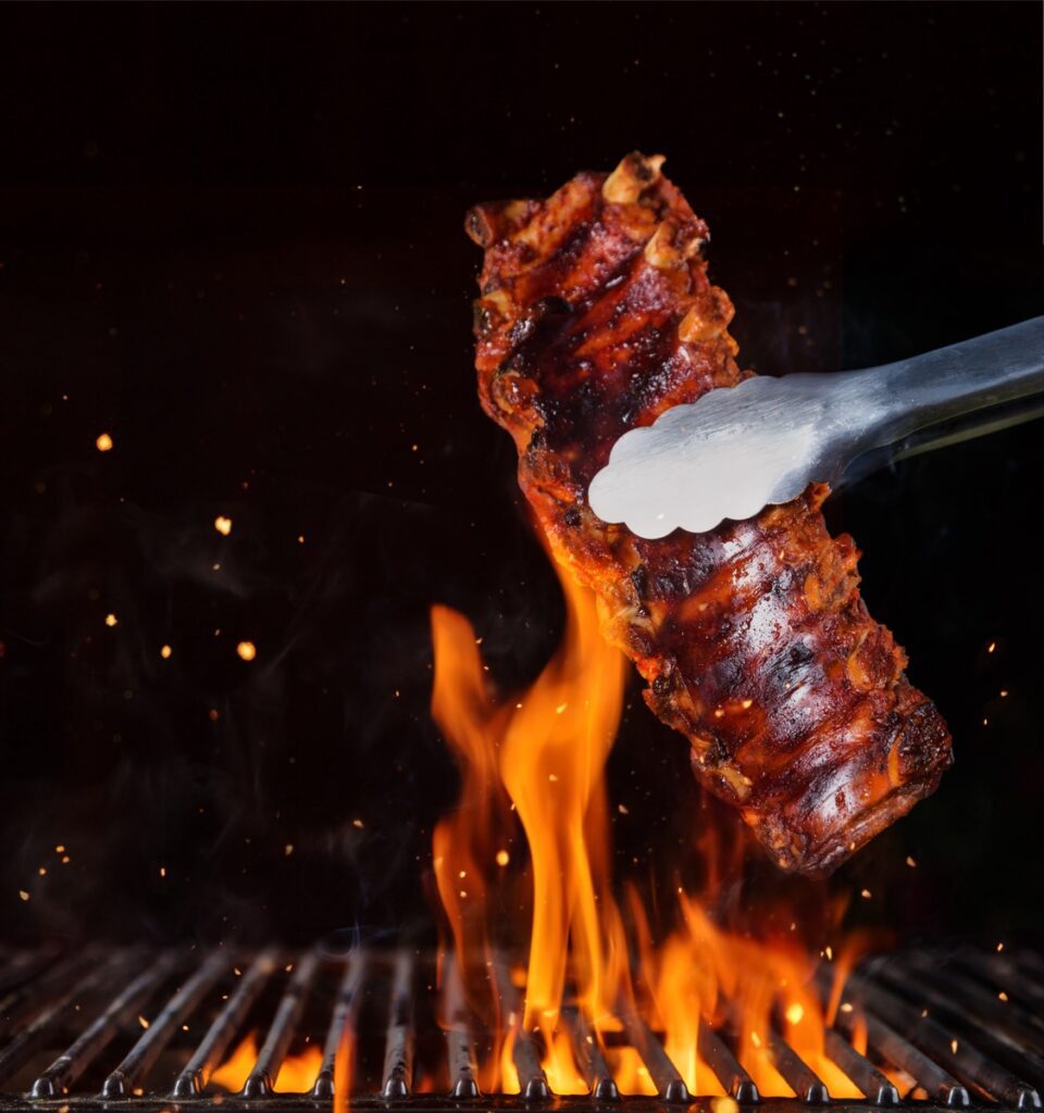 Pork,Ribs,Over,Flaming,Grill,Grid,,Isolated,On,Black,Background.