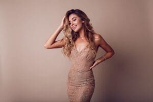 gorgeous woman with blonde wavy hair wearing elegant beige dress