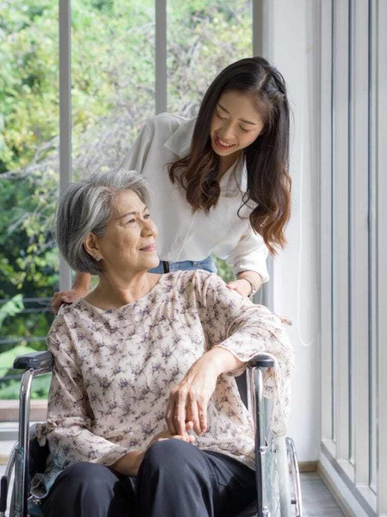 Young,Asian,Woman,Help,Pushing,A,Wheelchair,For,Grandma,In