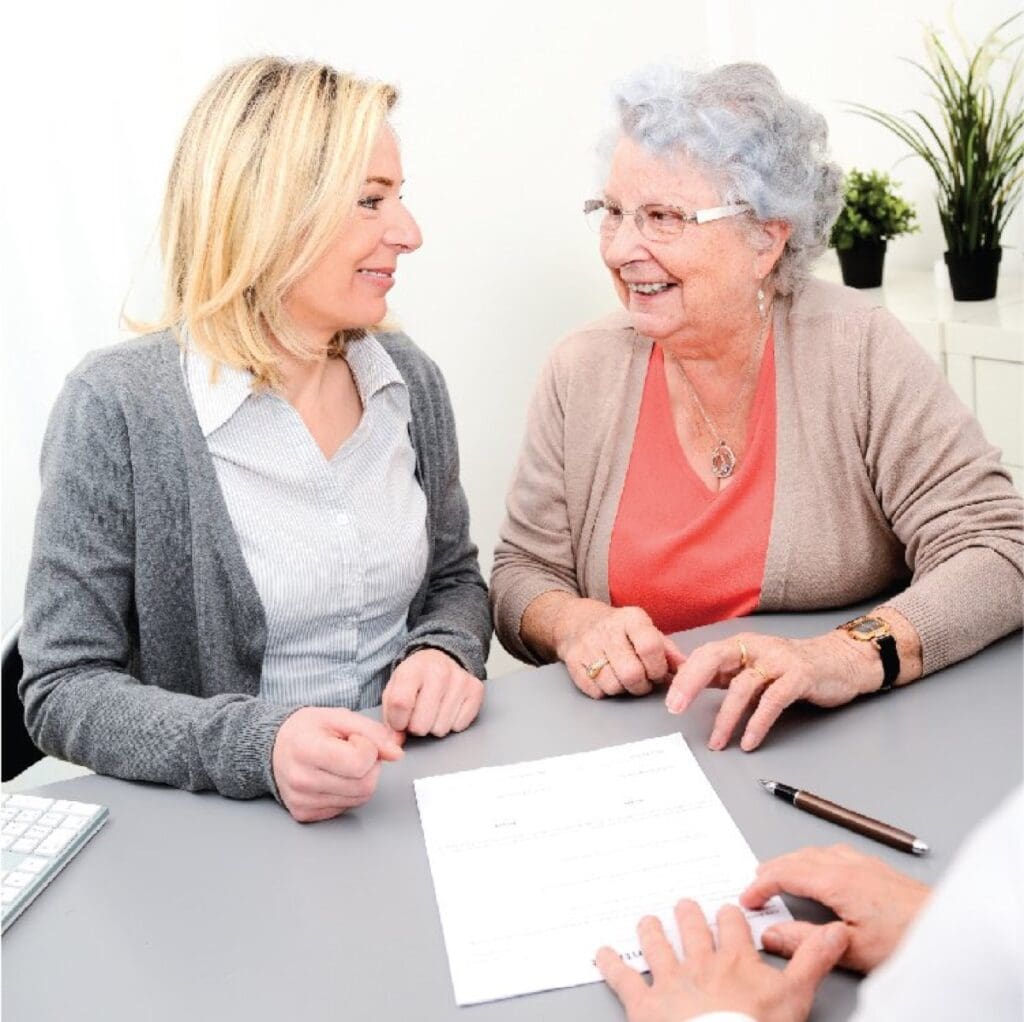 elderly senior woman with daughter signature legacy heritage testament document in a lawyer notary office