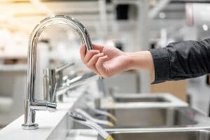 Male,Hand,Choosing,Stainless,Steel,Water,Tap,In,Furniture,Store.