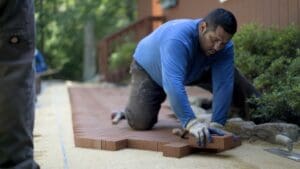 Man,Putting,Brick,Pavers,Into,Place,In,A,Herringbone,Pattern