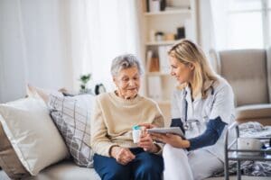 A,Health,Visitor,With,Tablet,Explaining,A,Senior,Woman,How